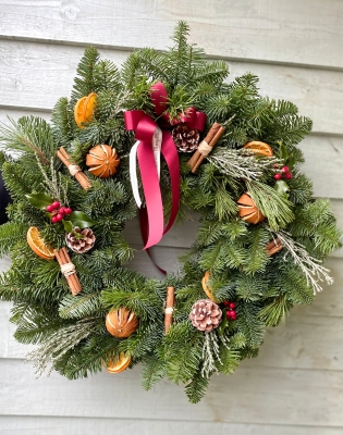 15” Spruce door wreath with dried fruit and cinnamon sticks.