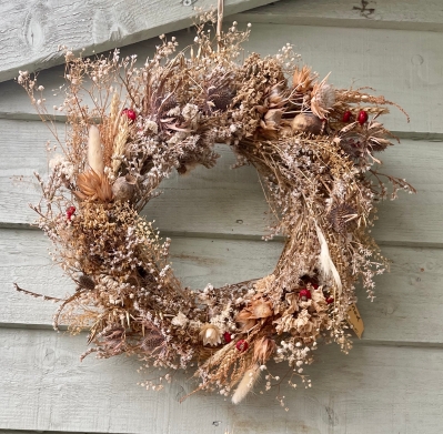 Rustic dried door wreath on a straw base.