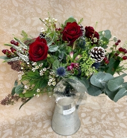 Festive bouquet arranged in an included silver jug.